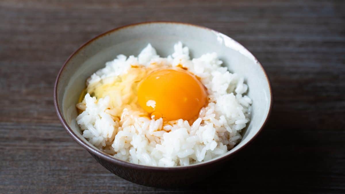 A bowl with rice and a raw egg.
