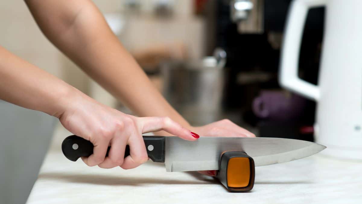 A woman sharpening a knife.