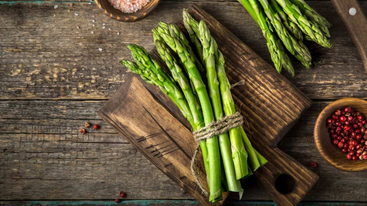 A bunch of asparagus on a wooden surface.
