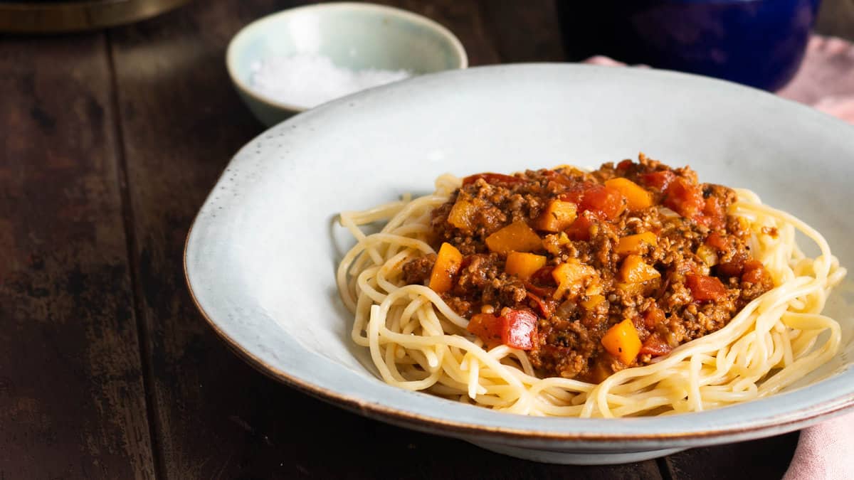 A bowl of instant pot bolognese served over pasta.