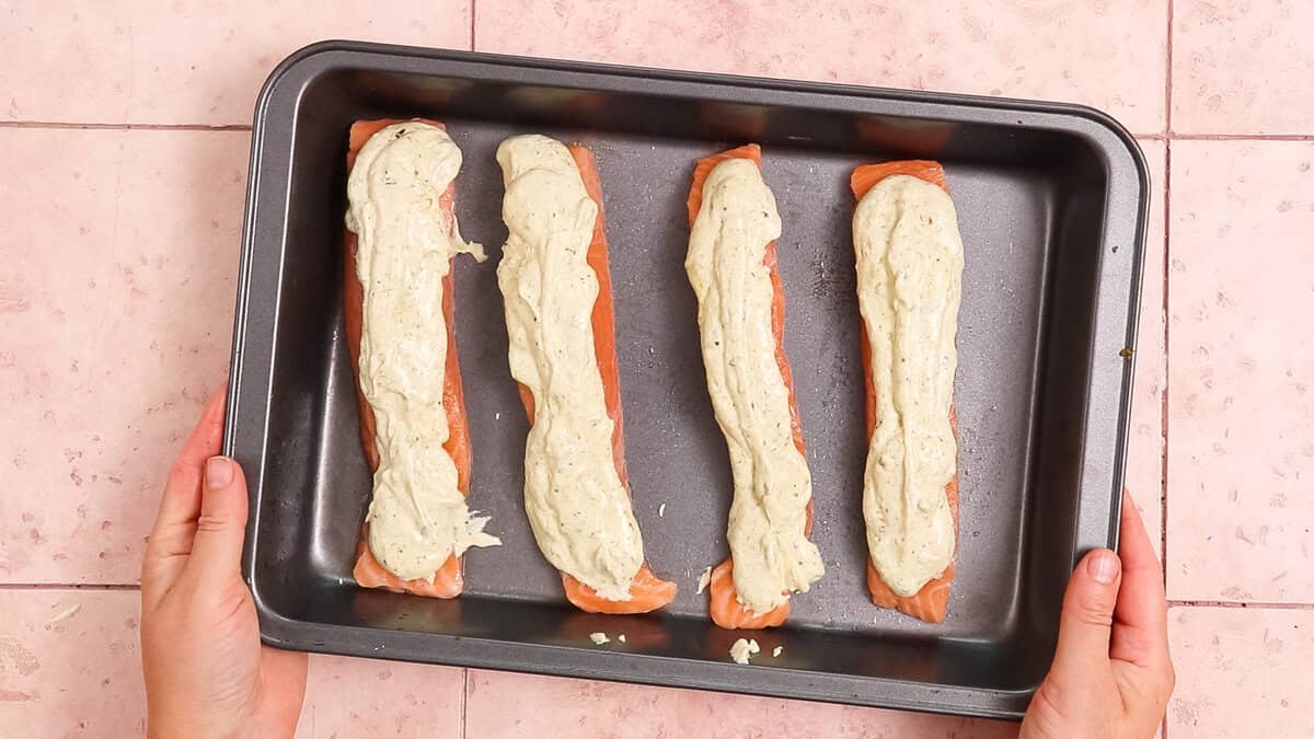 Salmon topped with pesto mixed with Greek yoghurt, before baking.