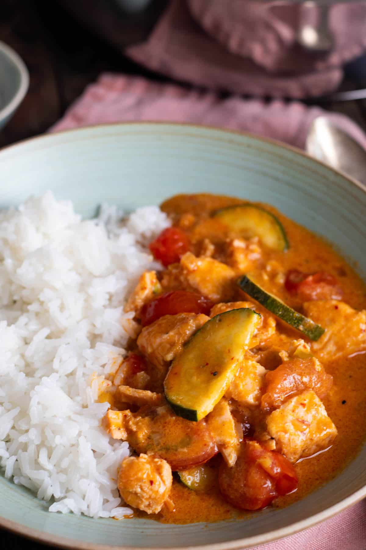 A bowl of thai salmon curry with rice.