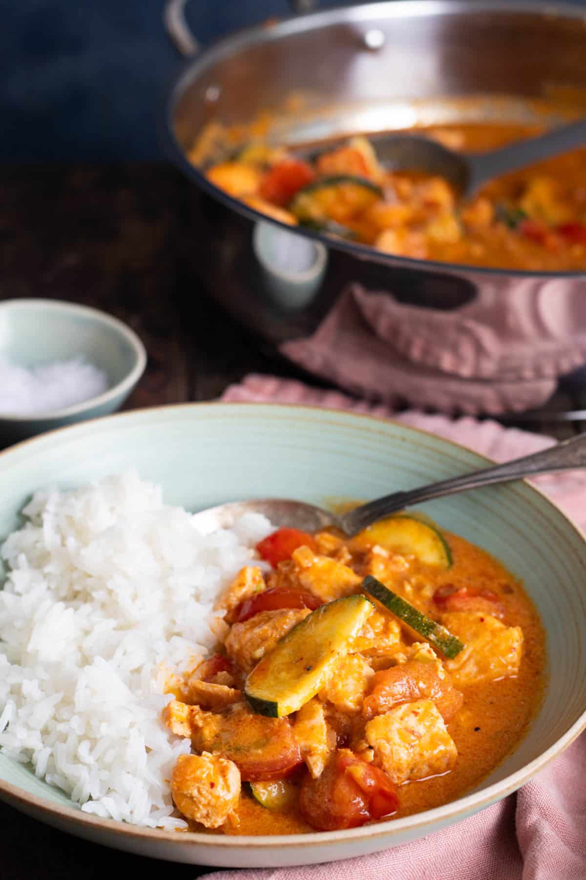 A bowl of thai salmon curry with rice.