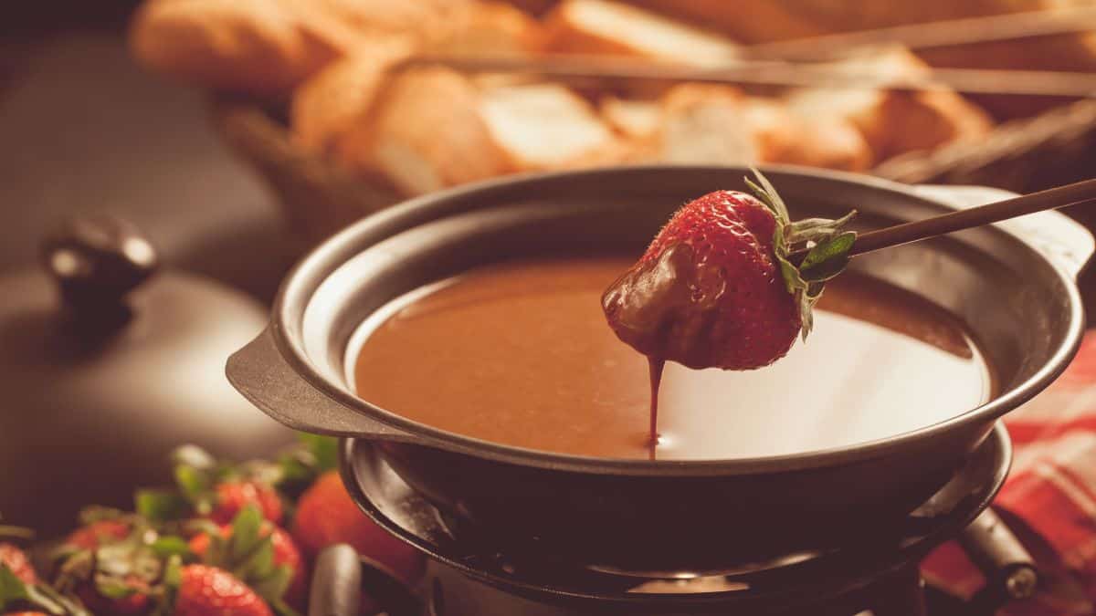 A strawberry dipped in chocolate fondue.