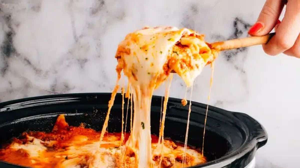 Crock pot lasagna being lifted out of the pot.