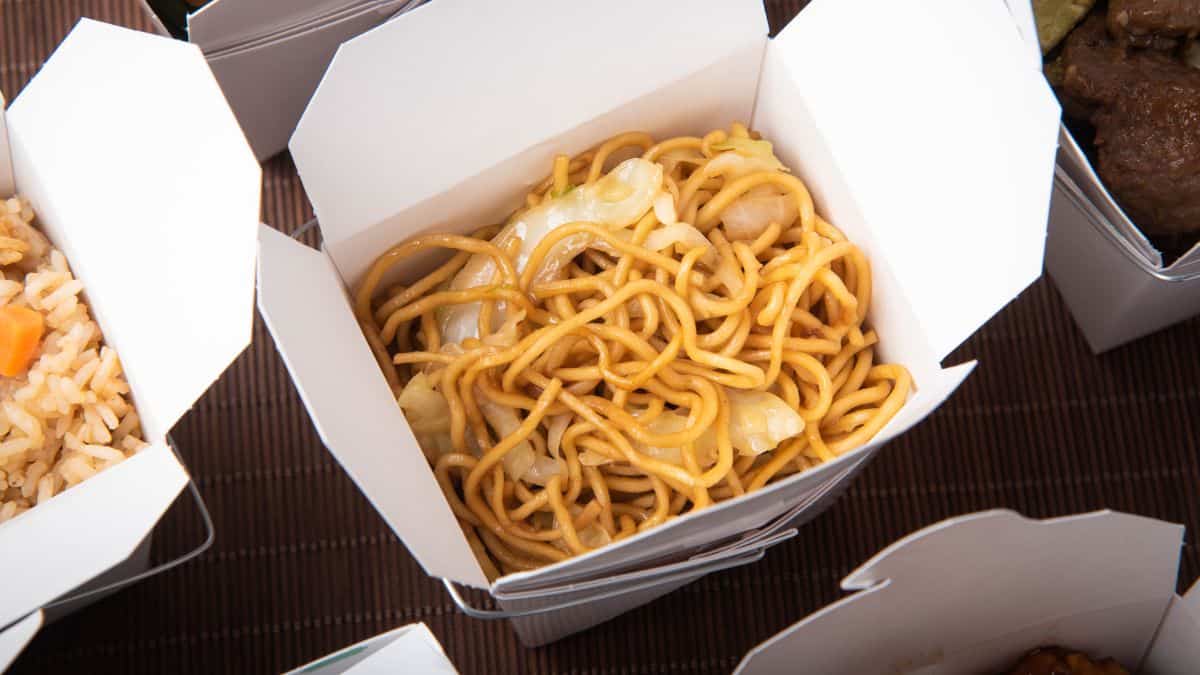 A takeout box with chow mein.