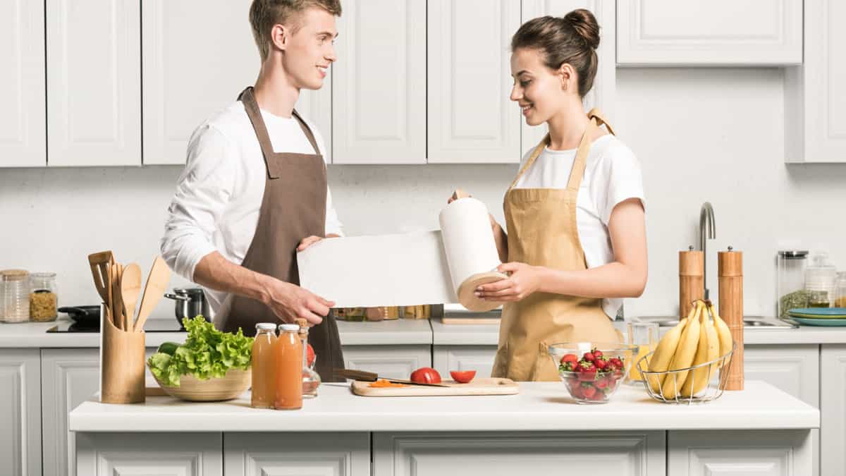 couple in kitchen with paper towel.