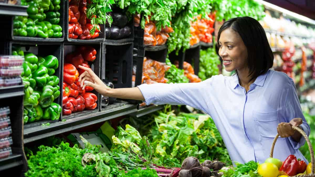 A woman shopping in the produce section of a grocery store.