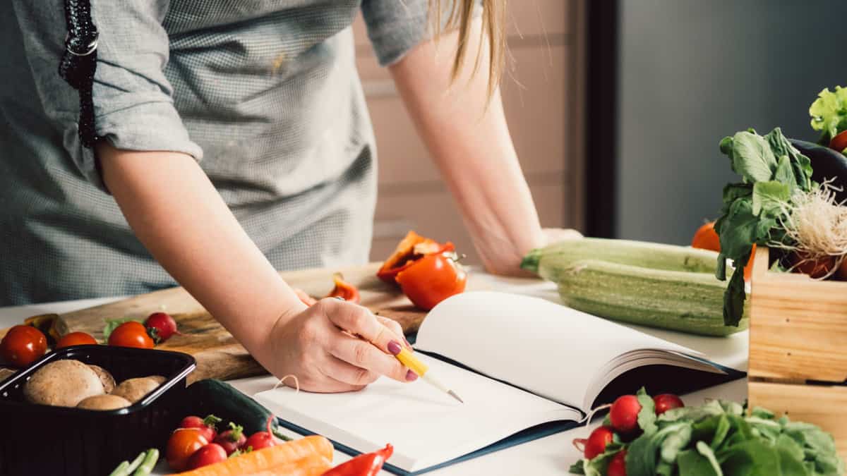 A woman taking notes on a recipe.