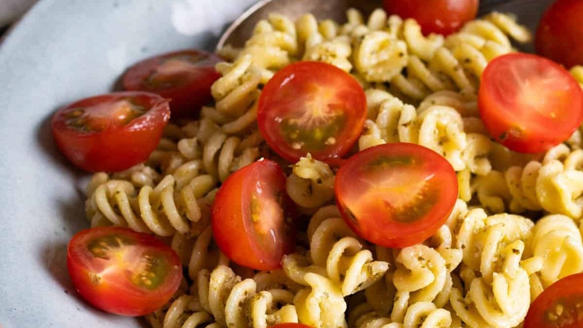 Creamy pesto pasta topped with cherry tomatoes.