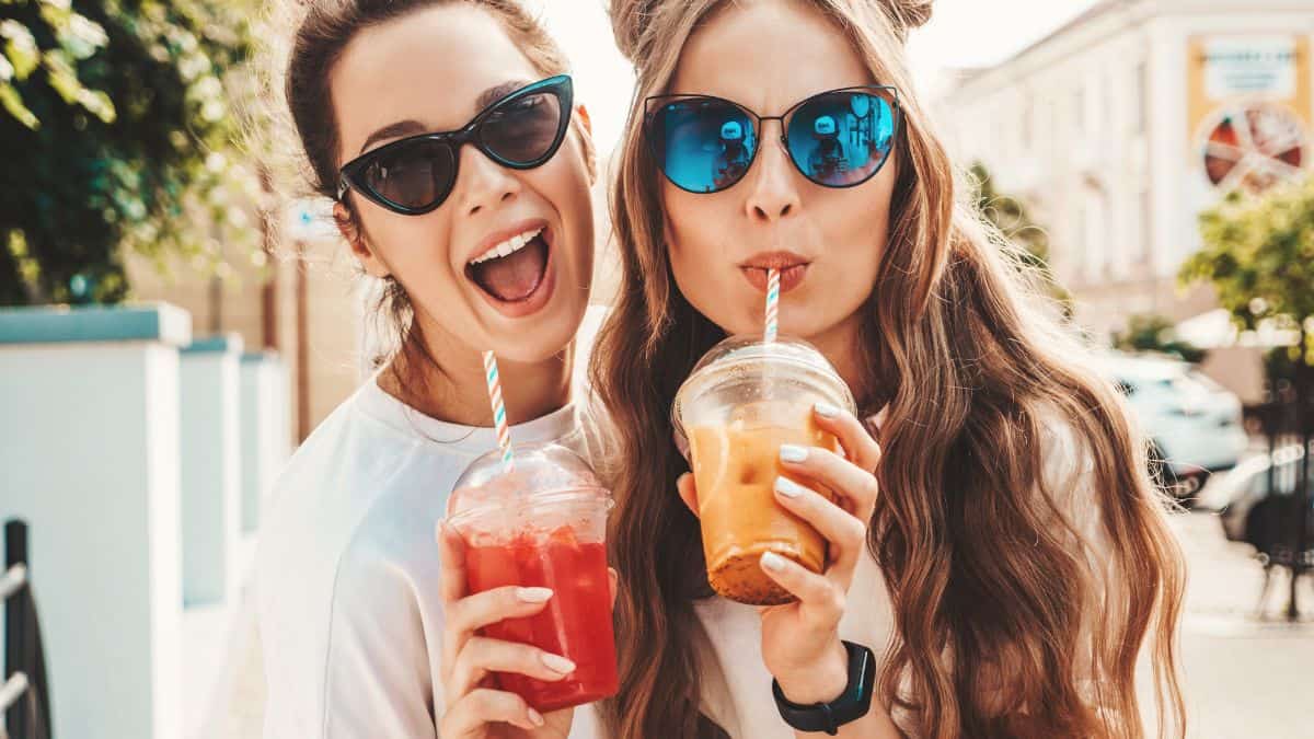 Two women drinking smoothies or juices.