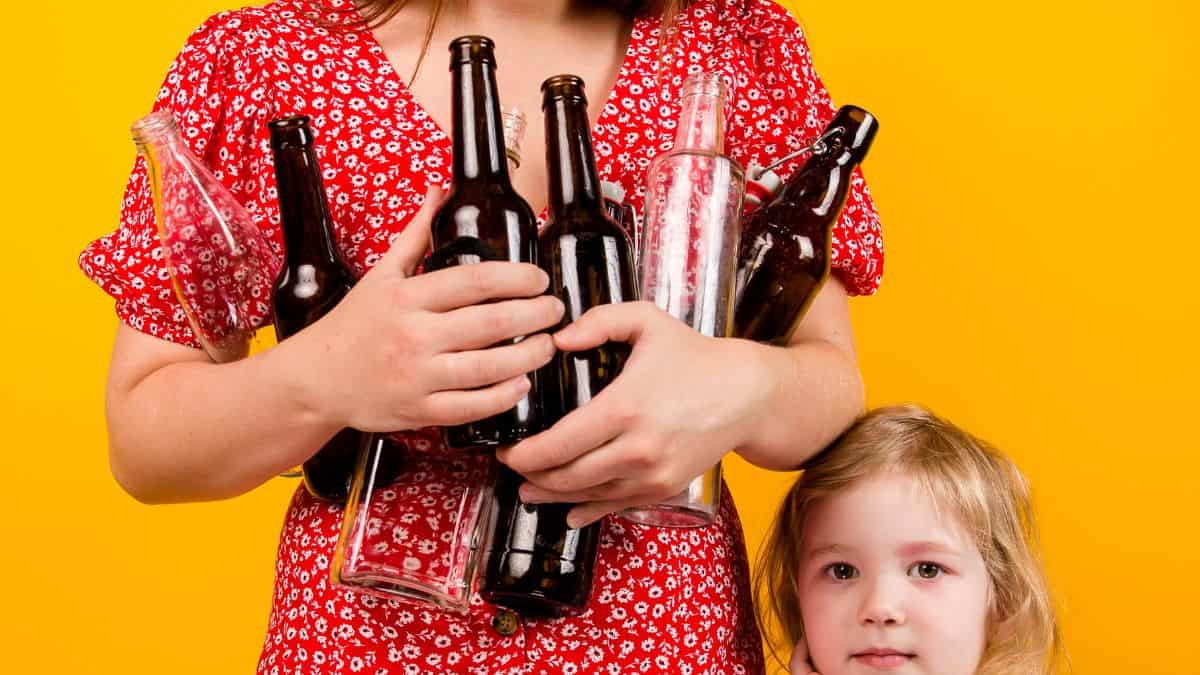 A woman holding bottles next to a child.