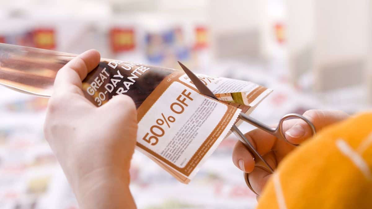 A person clipping a coupon.