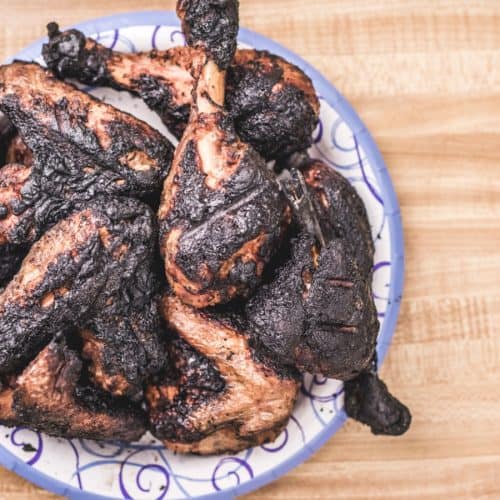 A plate full of burnt chicken.