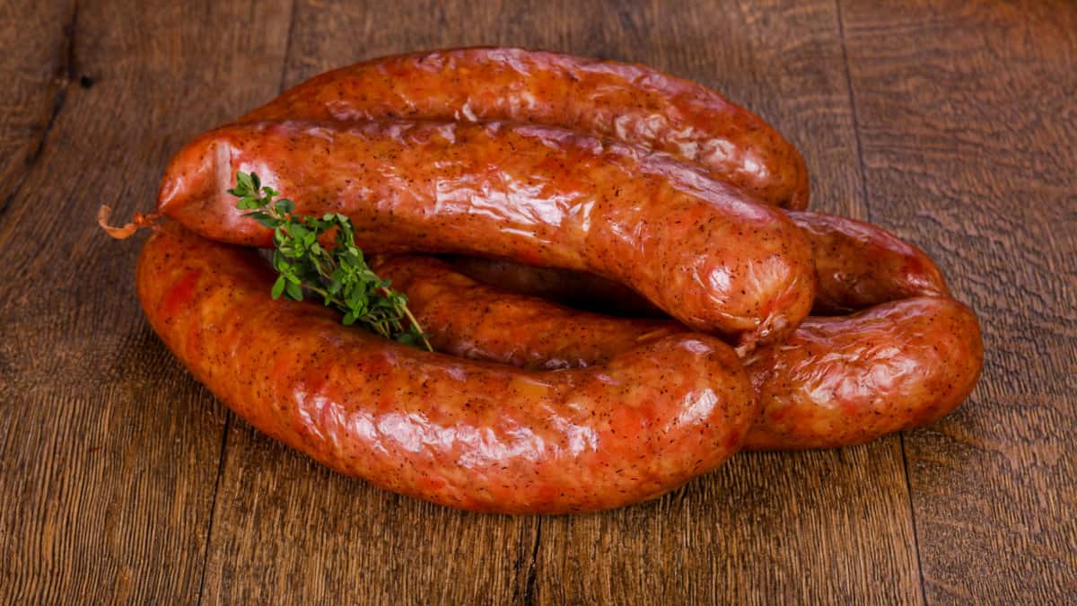 Pork sausages over wooden background.