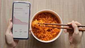 Eating a bowl of ramen noodles while looking at stocks crashing on the phone.