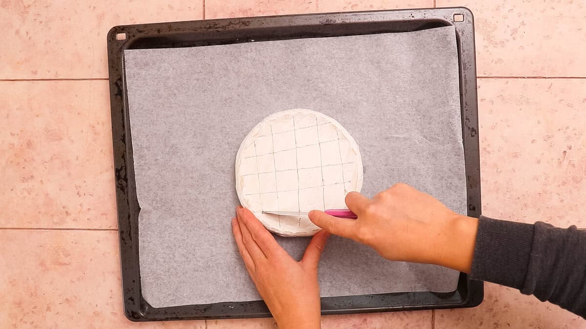 Scoring a brie cheese before baking.