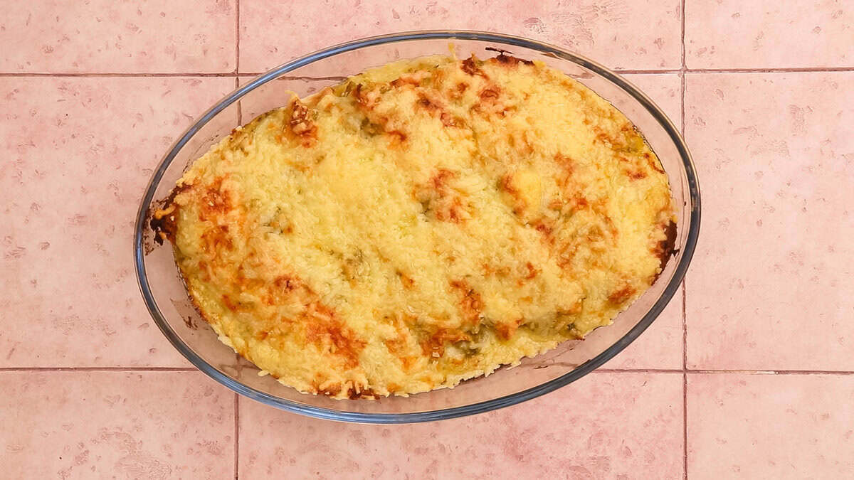 Chicken enchiladas topped with lots of cheese after baking.
