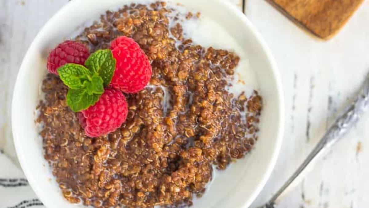 A bowl of chocolate porridge topped with raspberries.