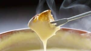 A piece of bread dipped in cheese fondue.