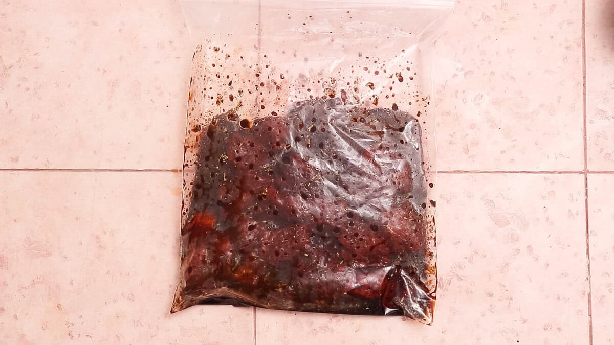 Marinating steak bites in a plastic bag.