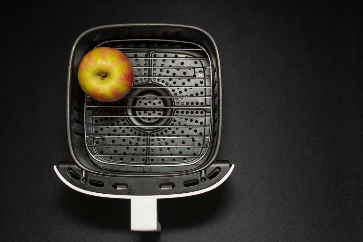 An apple in an air fryer basket.
