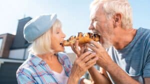 A boomer couple sharing a pastry.