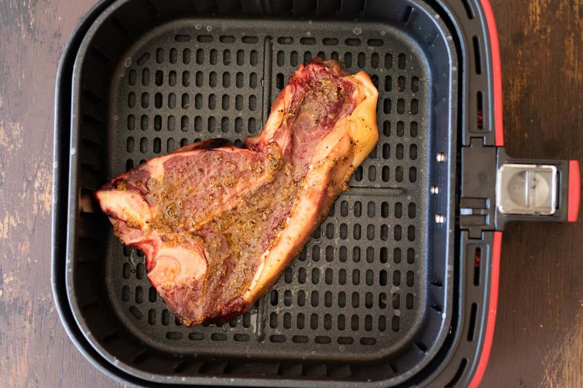 T-bone steak in air fryer before cooking.