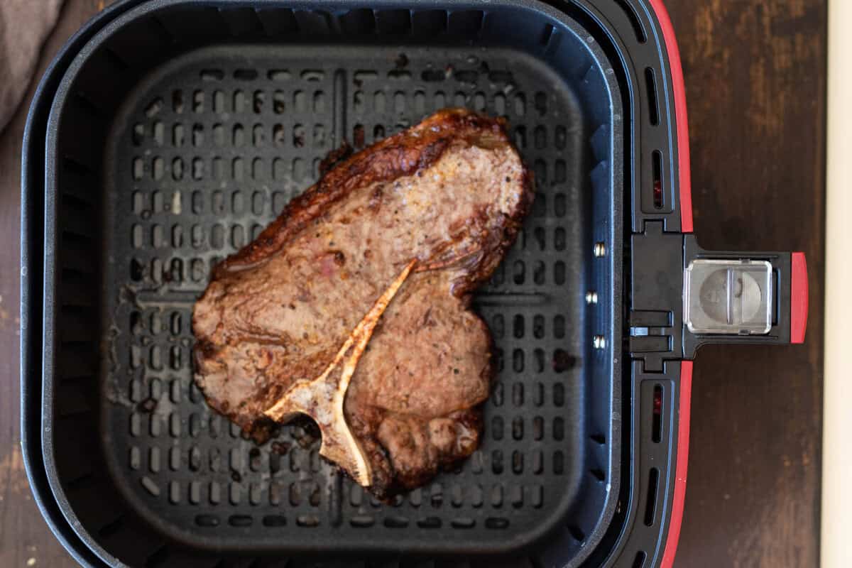 T-bone steak in air fryer after cooking.