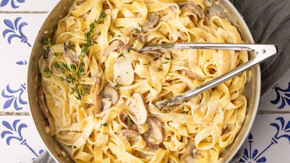  Creamy Mushroom Tagliatelle in a pan with tong.