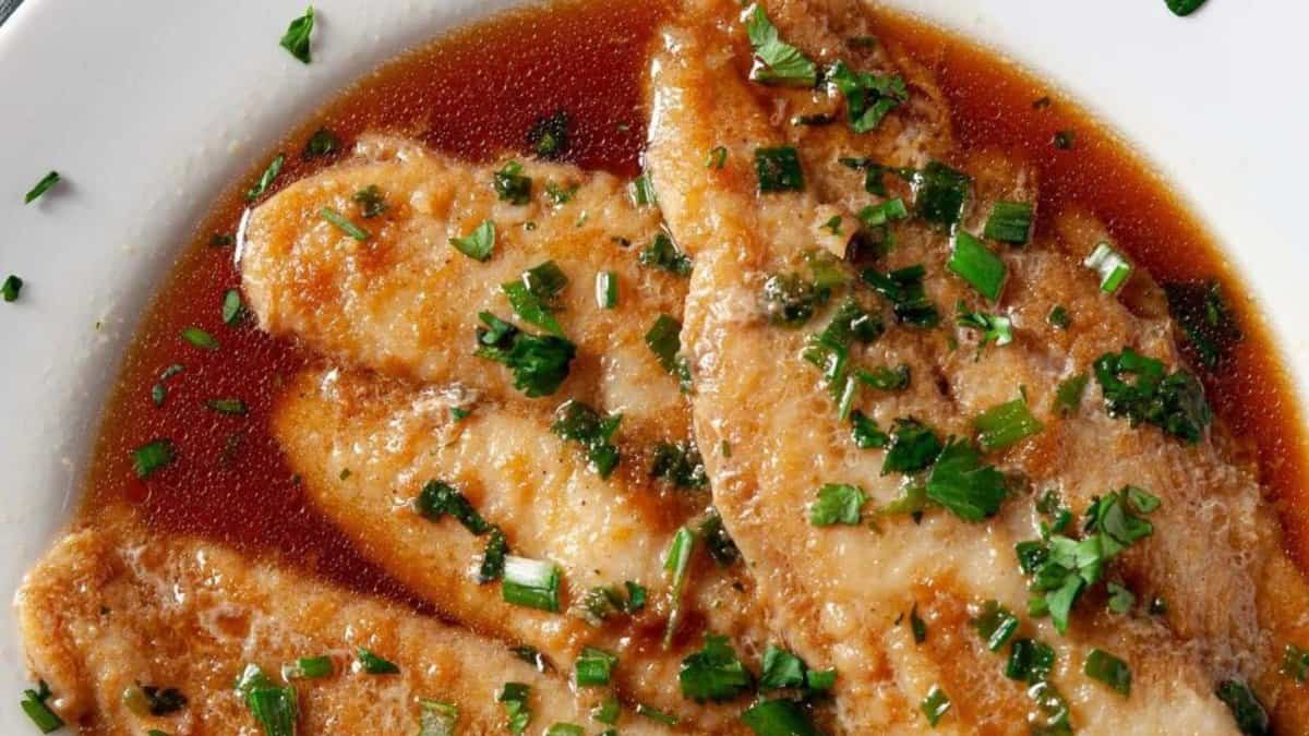Chinese-style steamed fish on a plate with sauce.