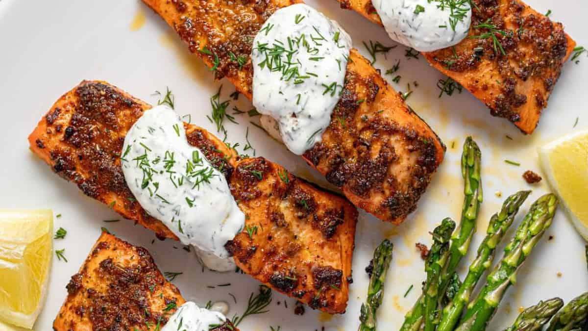 Air fryer salmon topped with creamy dill sauce.