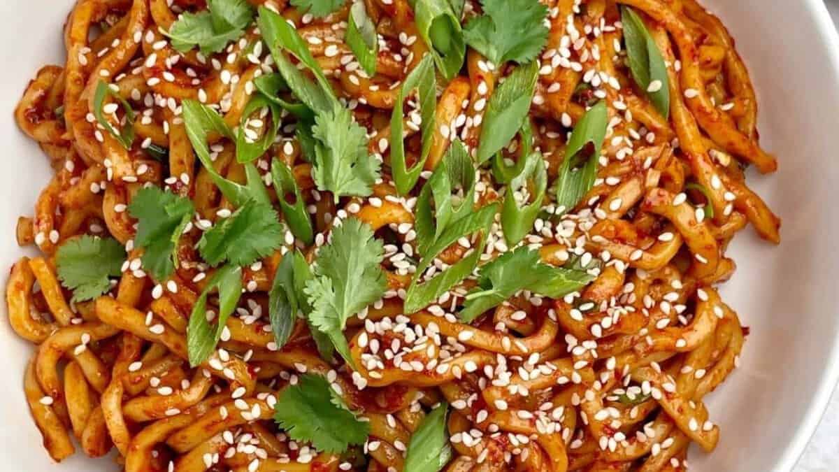 Chili oil noodles with sesame seeds and chopped scallions.