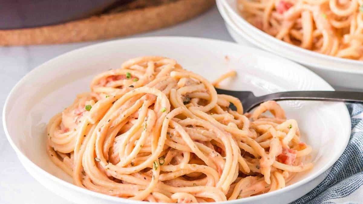 Pink pasta on a shallow, white bowl.