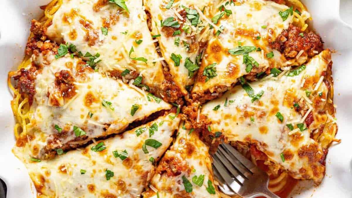 Sliced spaghetti pie on a round pan.