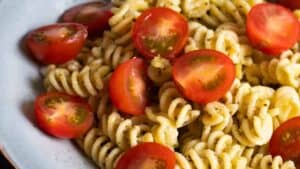 Pesto pasta topped with cherry tomatoes.