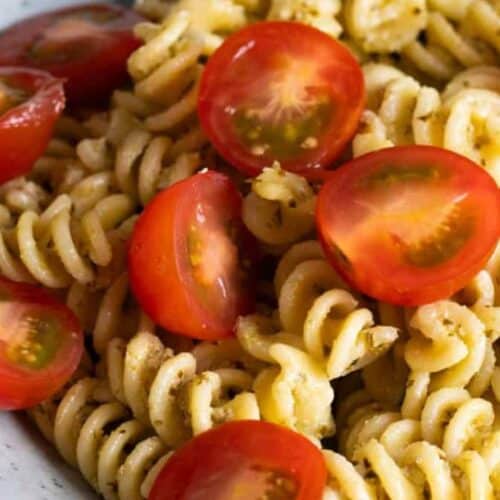 Pesto pasta topped with cherry tomatoes.