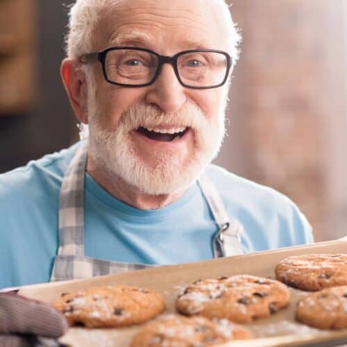 A man holding a pan of cookies.