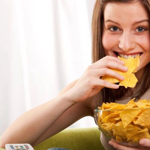 A woman eating chips.