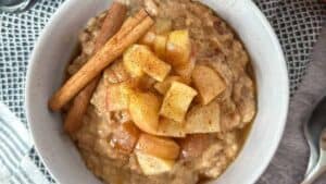 A bowl of oatmeal with apples.