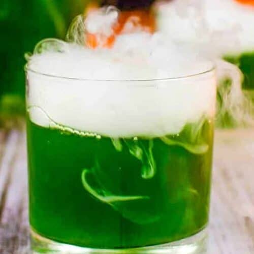 A green cocktail with smoke.