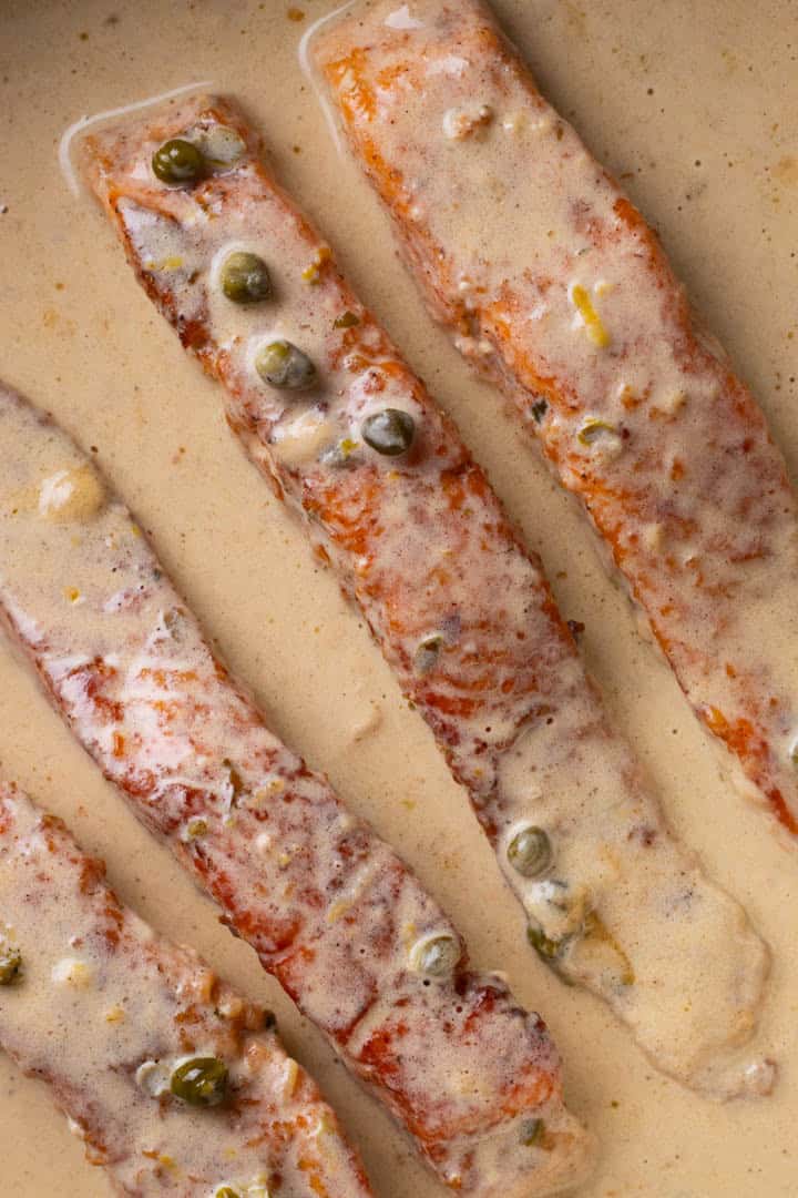 Salmon piccata in a skillet.