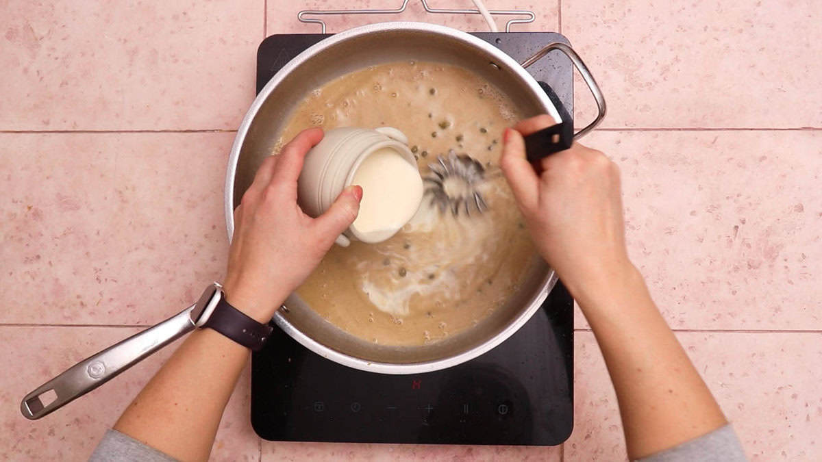 Adding cream to piccata sauce.