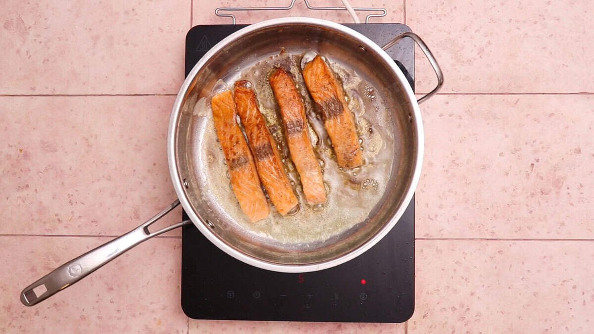 Seared salmon in a skillet.