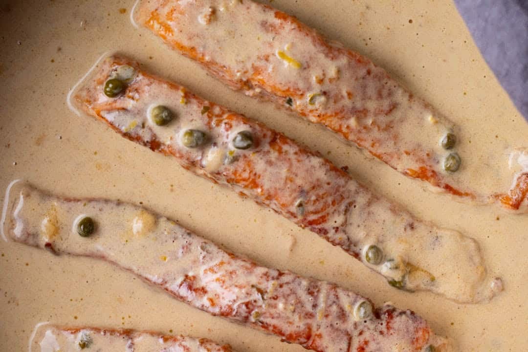 Salmon piccata in a skillet.