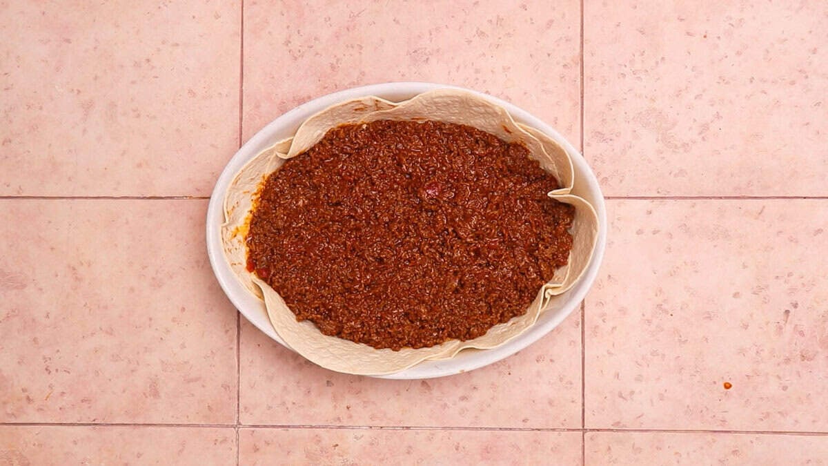 Tortillas and ground beef in a pan.