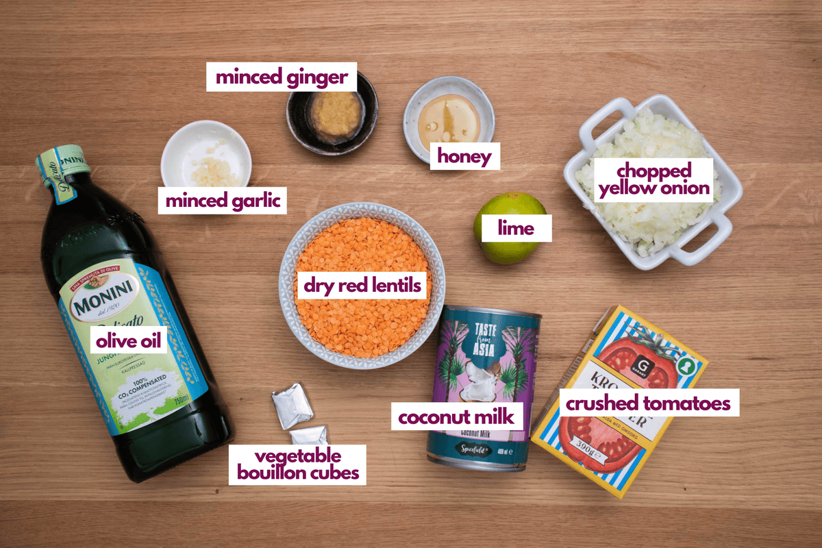 Ingredients needed for coconut lentil soup including onion, garlic, ginger and crushed tomatoes.