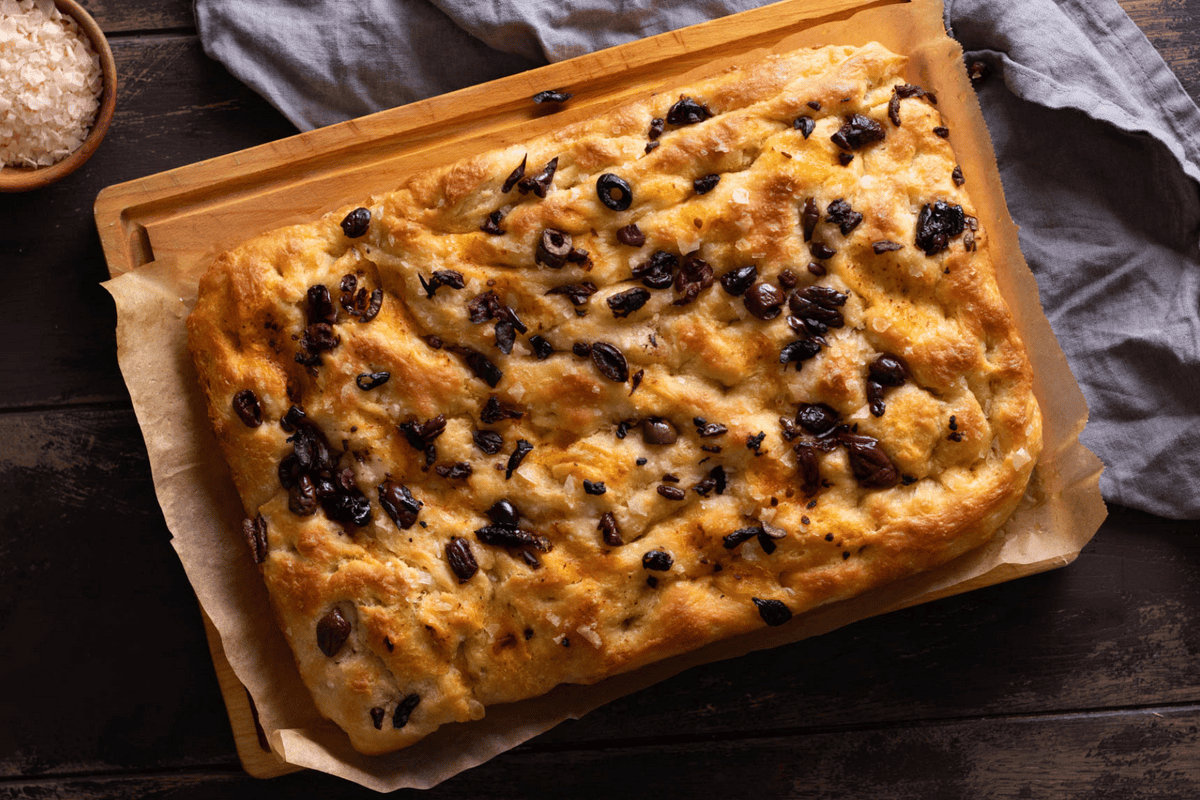 Top down view of an easy overnight focaccia topped with black olives and cut into squares.