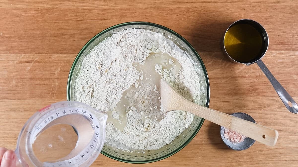 Adding water to focaccia dough.