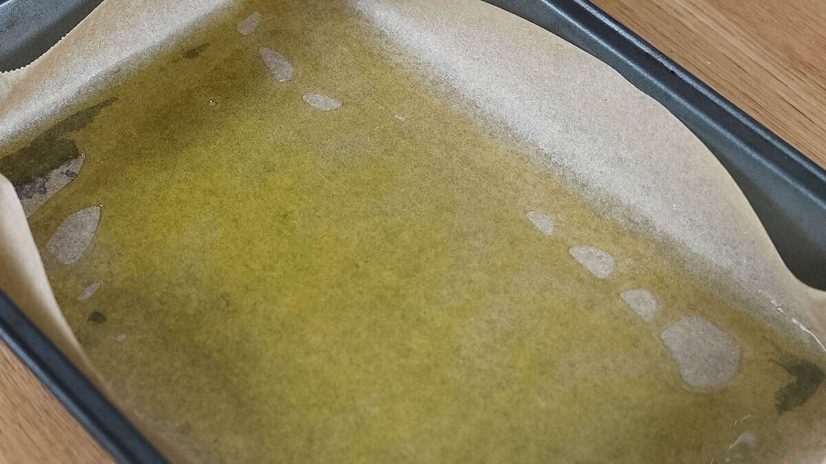 A lined pan with lots of olive oil, for making easy overnight focaccia.